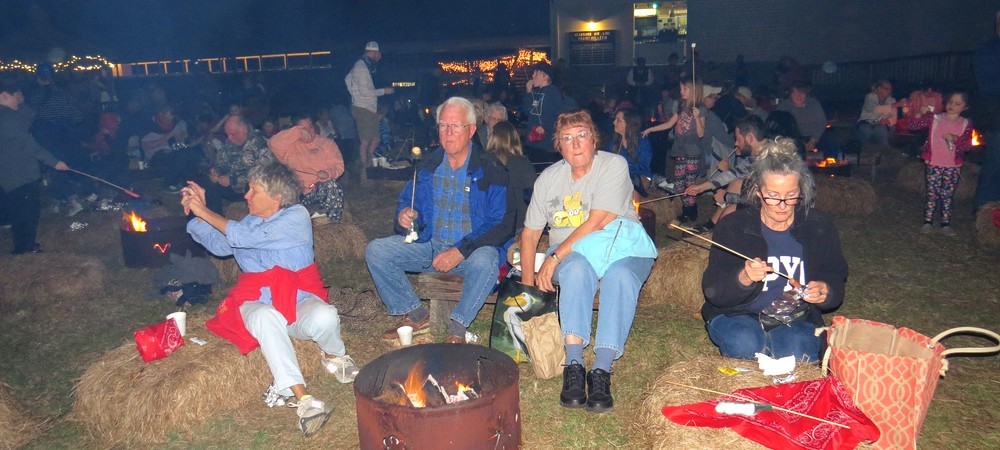 Members sitting around a small bondfire